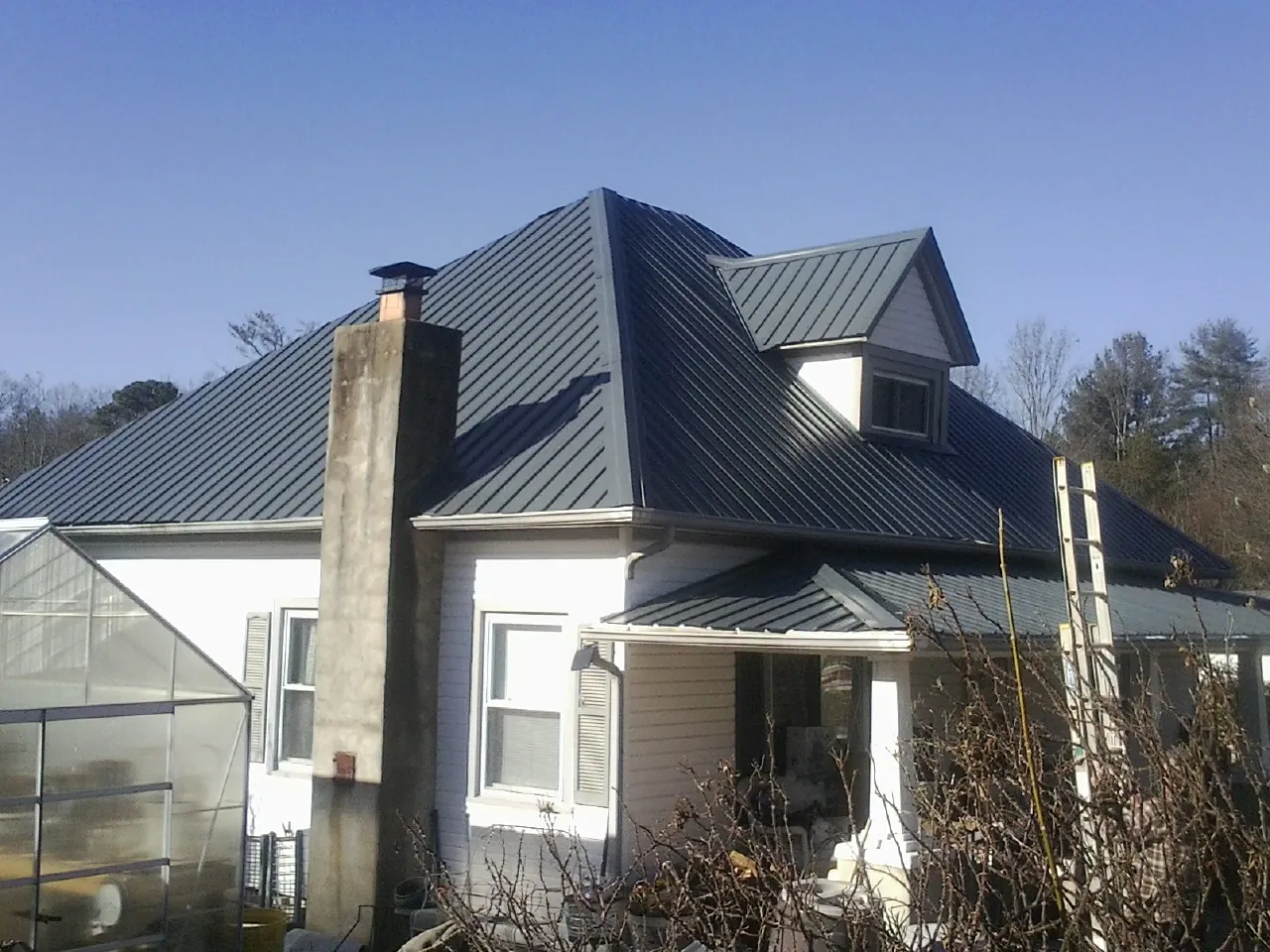Dark blue standing seam metal roof on a white farmhouse with dormer — Slate & Tile Roof Repair by Roofing Brothers in Mount Orab