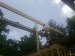 Carpenter setting a ridge beam over a new addition frame — Ice Dam Removal by Roofing Brothers in Mount Orab
