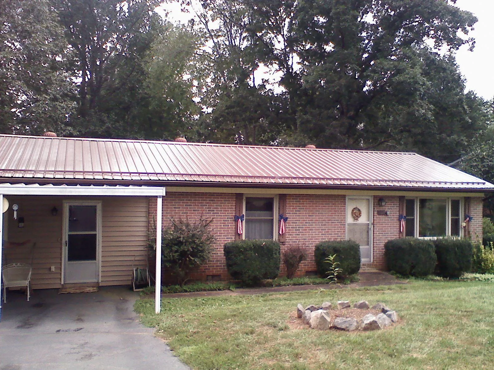 Bronze metal roof and carport on a brick ranch home — Roof Repair work by our crew in Mount Orab